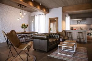a living room with a leather couch and a kitchen at Villa Vivere in Asos