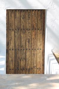 a wooden door in the side of a building at B&B Casa Luz del Sur, adults only in Alhaurín el Grande