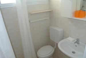 a bathroom with a white toilet and a sink at Appartamento CRISTALLO 25 in Lignano Sabbiadoro