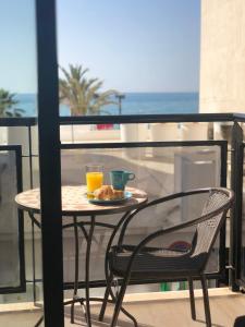 フエンヒロラにあるApartamento lujoso con Vista al Marのテーブルと椅子(食品プレート、オレンジジュース付)