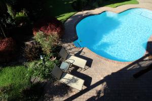 an overhead view of a swimming pool with tables and chairs at Oak Park and Conference Centre in Kokstad