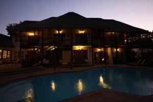 ein Haus mit einem Pool vor einem Gebäude in der Unterkunft Oak Park and Conference Centre in Kokstad