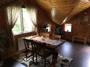 d'une salle à manger avec une table, des chaises et des fenêtres. dans l'établissement Gästvåning i Hajstorp, à Töreboda