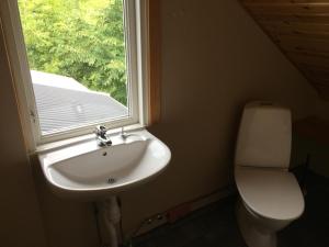 La salle de bains est pourvue d'un lavabo, d'une fenêtre et de toilettes. dans l'établissement Gästvåning i Hajstorp, à Töreboda