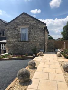 a stone house with a walkway in front of it at Camerton Inn Cottage in Bath