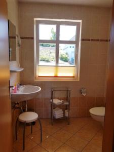 a bathroom with a sink and a toilet and a window at Über dem Meer in Lohme