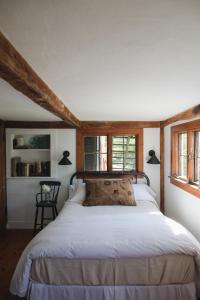 a bedroom with a large white bed with windows at Squire Tarbox Inn in Westport
