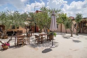 Un patio con sombrilla, mesas y sillas. en La Locanda di Zì Nicola, en Matera