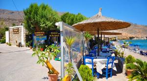 a group of chairs and umbrellas on a beach at Beachfront Apartment Kato Zakros in Kato Zakros