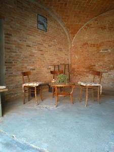 een groep houten tafels en stoelen in een bakstenen muur bij Casa Aromi ed Arte in Asti