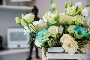 ein Strauß von weißen und blauen Blumen in einer Vase in der Unterkunft Residenza Elisa in Desenzano del Garda