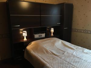 a bedroom with a large bed with two lights on it at La Maison de Gaston in Saint-Cirgue