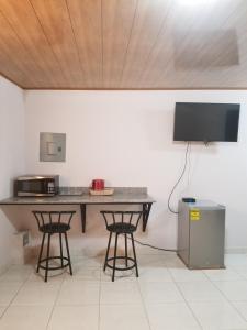 a kitchen with a table and two bar stools at B&B Lodgings in Tocumen