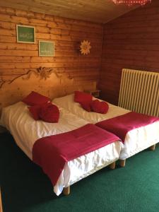 2 letti in una camera con pareti in legno di Hôtel les skieurs a Bellevaux