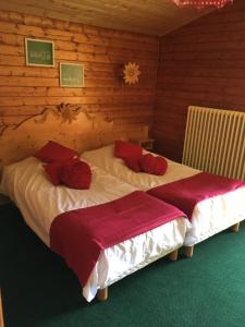 two beds in a room with wooden walls at Hôtel les skieurs in Bellevaux +48 photos