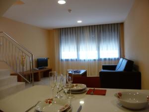 a dining room table with chairs and a television at Hotel Verti in Corró de Vall