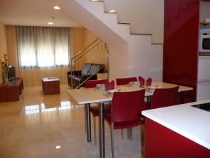 a kitchen with tables and red chairs and a staircase at Hotel Verti in Corró de Vall