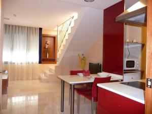 a kitchen and dining room with a table and red chairs at Hotel Verti in Corró de Vall