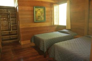 a bedroom with two beds and a painting on the wall at La Musa Verde in Tarapoto