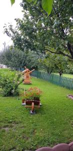 um jardim com um moinho de vento e flores na relva em Cazare La Troita em Codlea