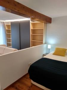 1 dormitorio con cama y estanterías en Apartamento Mercaderes, en Pamplona