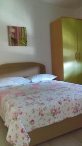 1 cama con manta de flores y armario verde en Ruža i Natalija, en Karlobag