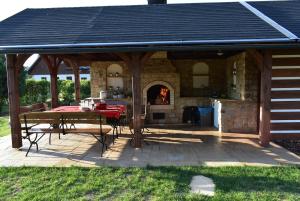 einem Holzpavillon mit einem Tisch und einem Kamin in der Unterkunft Villa Harta in Vrchlabí