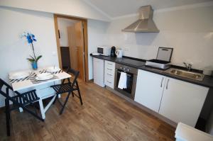 eine Küche mit einem Tisch und einem Waschbecken sowie einem Tisch und Stühlen in der Unterkunft Angelas - Casa Da Eira in Vila Praia de Âncora + 11 Fotos