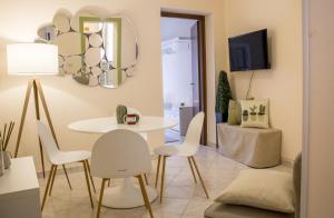 - un salon avec une table et des chaises blanches dans l'établissement Apartment Rome & More, à Rome