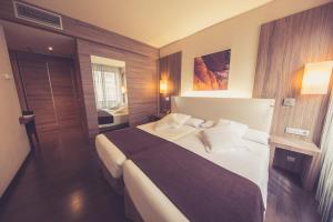ein Schlafzimmer mit einem großen Bett in einem Zimmer in der Unterkunft Hotel Aroi Ponferrada in Ponferrada