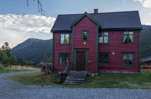 Maristuen Fjellferie في Borgund: منزل احمر فيه جبال في الخلف
