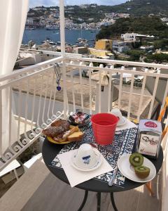 una mesa con un plato de comida en el balcón en B&B Ponza Suite en Ponza