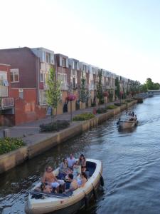 um grupo de pessoas andando em um barco em um rio em Bij Paul in Almere em Almere