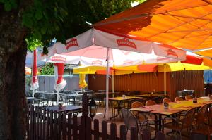 an outdoor restaurant with tables and umbrellas at Hotel Schiff in Horn