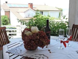 stół z butelką wina i wazonem kwiatów w obiekcie Apartment BLUE Jelsa w mieście Jelsa