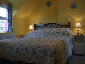 een slaapkamer met een bed met een bloemenbed bij Reenmore Farmhouse in Ahakista
