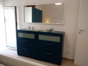 a bathroom with a blue dresser and a mirror at La Casa sul Mare - Veliero in Balestrate +40 photos