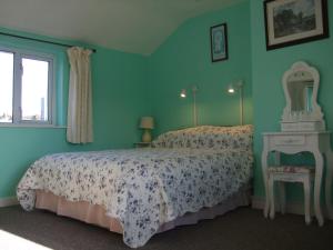 1 dormitorio con cama, espejo y ventana en Reenmore Farmhouse, en Ahakista