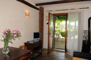 a living room with a television and a desk with a computer at Villa Eleanto in Cefalù