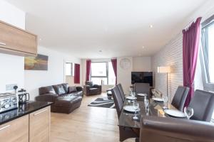 a kitchen and living room with a table and chairs at Stylish Penthouse Suite in Edinburgh