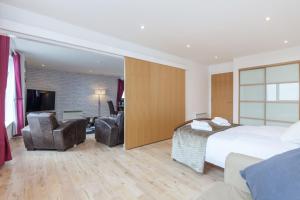 a hotel room with a bed and a living room at Stylish Penthouse Suite in Edinburgh