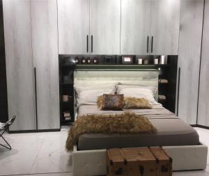 a bedroom with a large bed with a black headboard at Le Case di Loris in SantʼAntìoco