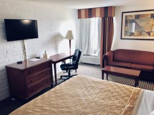 a hotel room with a bed and a desk and a couch at Knights Inn Dayton by Miller Lane in Dayton