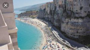 Ein Strand mit vielen Menschen und dem Ozean in der Unterkunft Pousada Romantica in Tropea