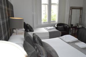 een hotelkamer met 2 bedden en een stoel bij Edinburgh37 in Edinburgh