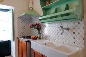 a kitchen with a sink and a vase of flowers at Villa Eleanto in Cefalù