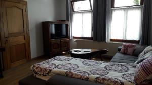 a living room with a bed and a couch and a tv at Casa Andres in Malmedy