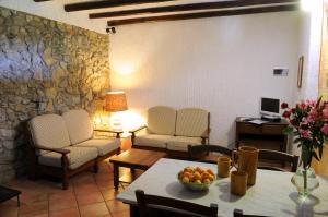 a living room with chairs and a table with fruit on it at Villa Eleanto in Cefalù