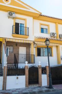 a white house with a black fence and a street light at Casa Saki in Armilla