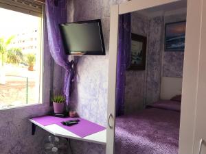 a room with a tv and a table with a window at Rooms Complex "Cristimar", Los Cristianos in Los Cristianos